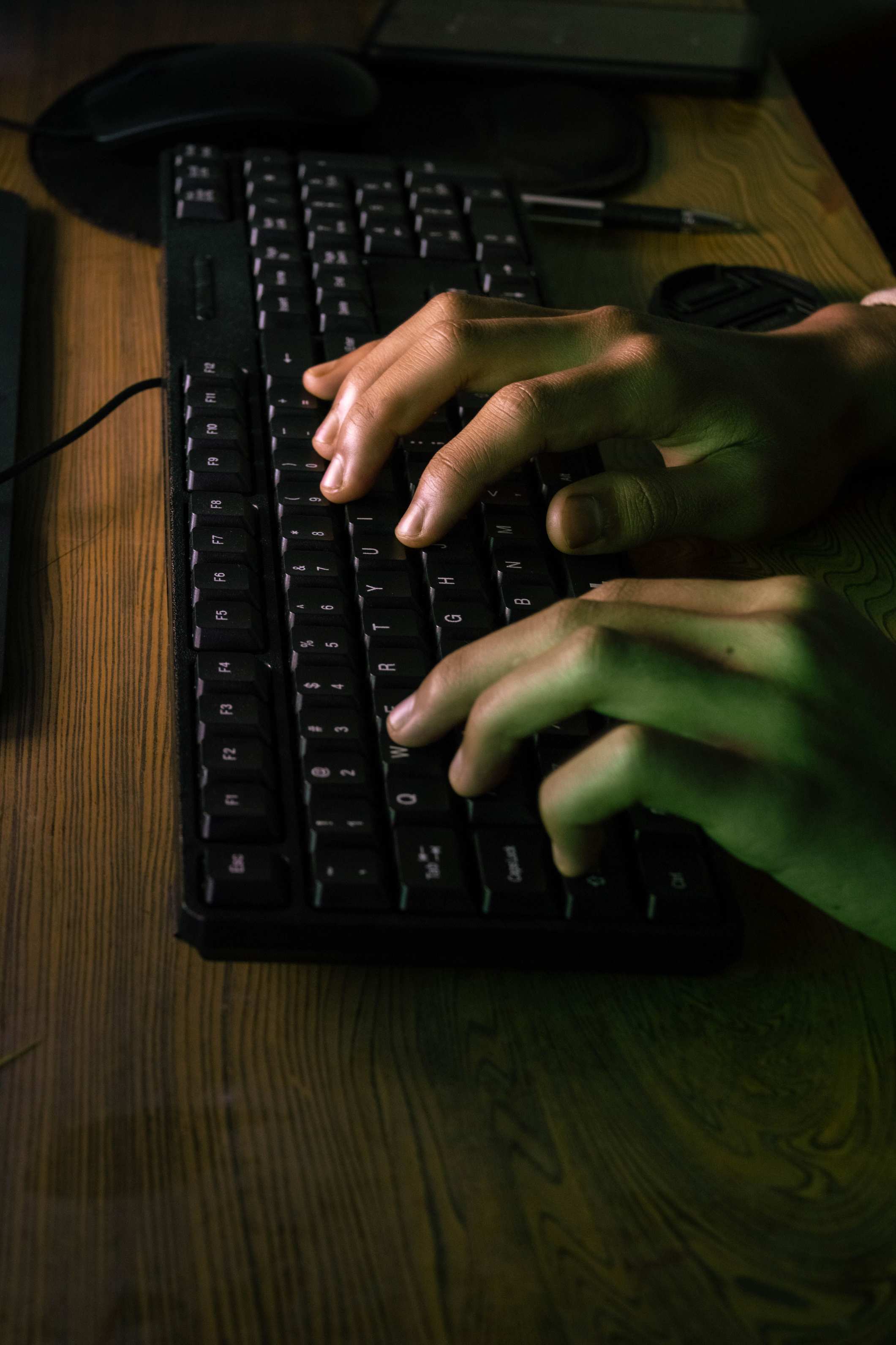 Hands typing on a keyboard while working at a computer, focused working atmosphere